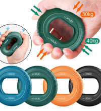 Hand holding a green resistance ring with load indicators, surrounded by other resistance rings in different colors and weights.